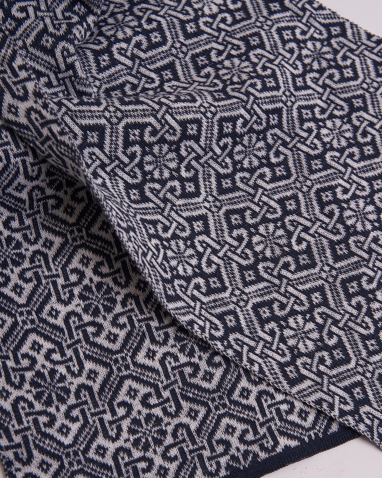 elegant navy blue scarf with a detailed brown geometric pattern and solid brown edges, displayed on a white background, showcasing the intricate design and sophisticated style