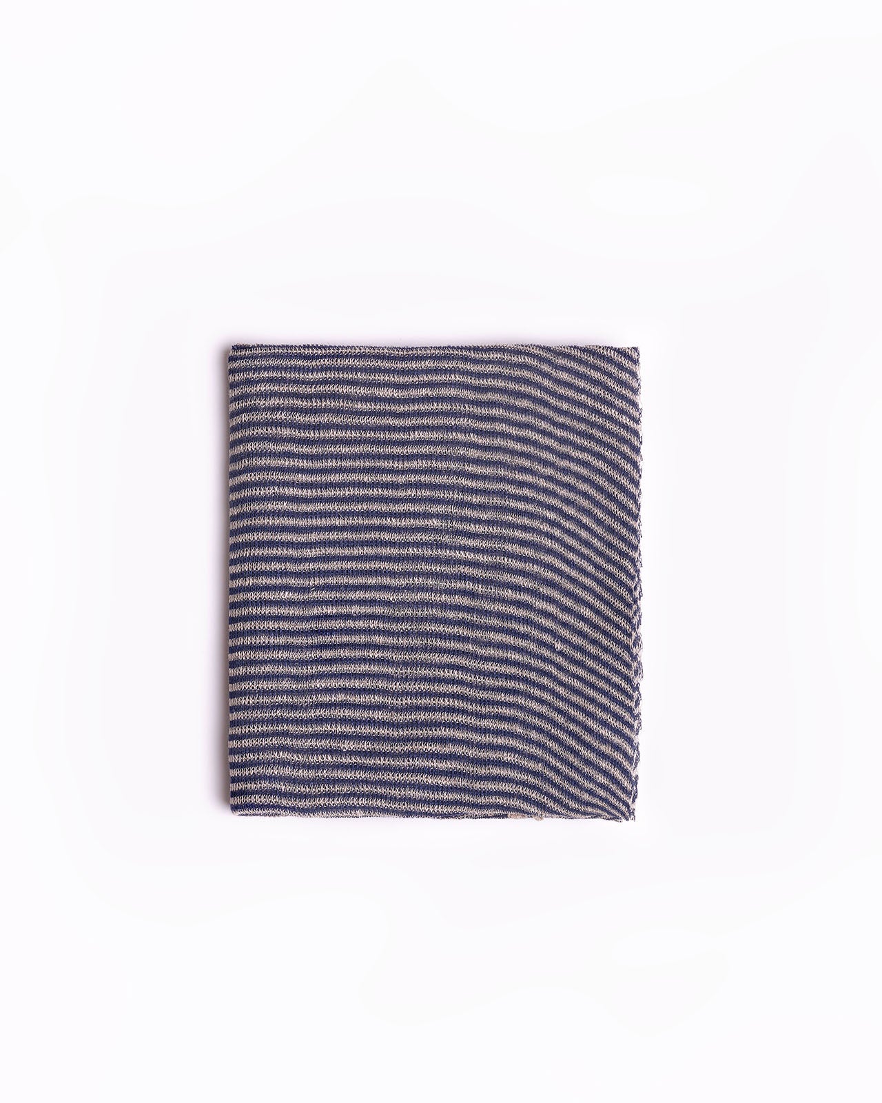High-quality navy blue striped scarf folded neatly against a clean white background. This scarf features a classic striped design in shades of beige, ideal for adding a touch of elegance to any outfit. The soft fabric and neutral tones make it a versatile accessory for both casual and formal occasions. Perfect for those searching for timeless fashion pieces