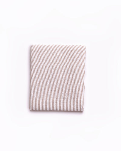High-quality linen beige striped scarf folded neatly against a clean white background. This scarf features a classic striped design in shades of beige, ideal for adding a touch of elegance to any outfit. The soft fabric and neutral tones make it a versatile accessory for both casual and formal occasions. Perfect for those searching for timeless fashion pieces