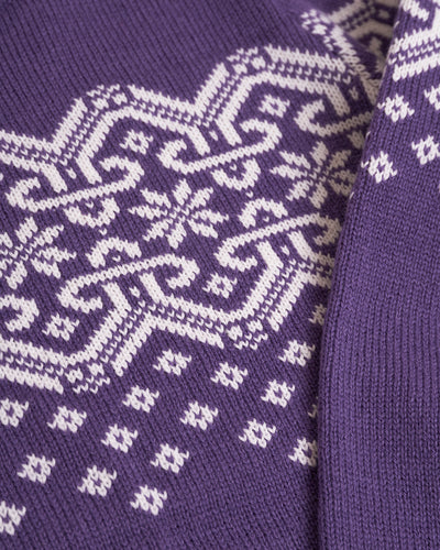 wgite ornament on purple sweater